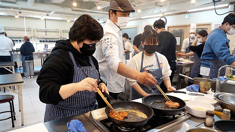 남성렬 셰프가 참가 학생들에게 치킨 스테이크 굽는 법을 시연하고 있다.